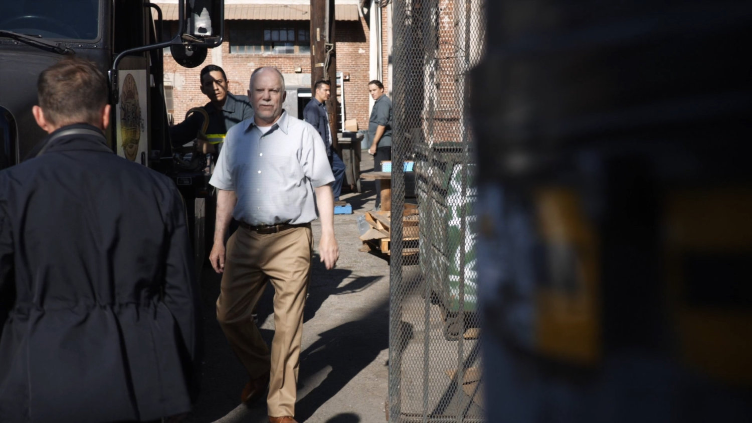 A warehouse manager approaches SHIELD agents.