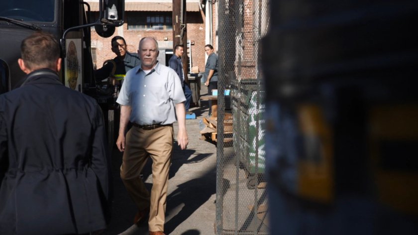 A warehouse manager approaches SHIELD agents.