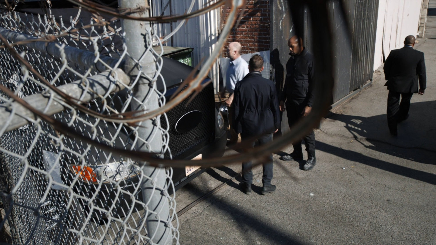 Coulson, Mack, and the warehouse manager outside a warehouse.