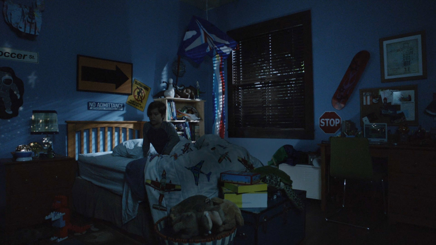 A young boy in his bedroom at night.