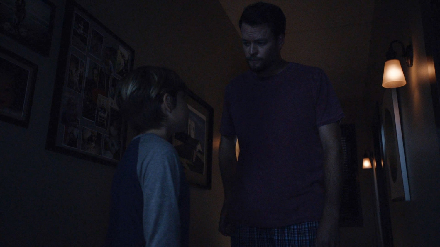 A young boy and his father in the hallway of their house.