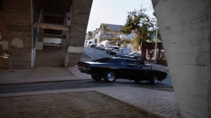 Robbie's black Charger driving away from his house.