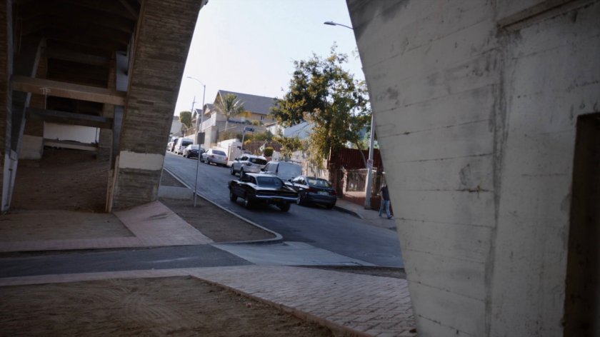 Robbie's black Charger driving away from his house.