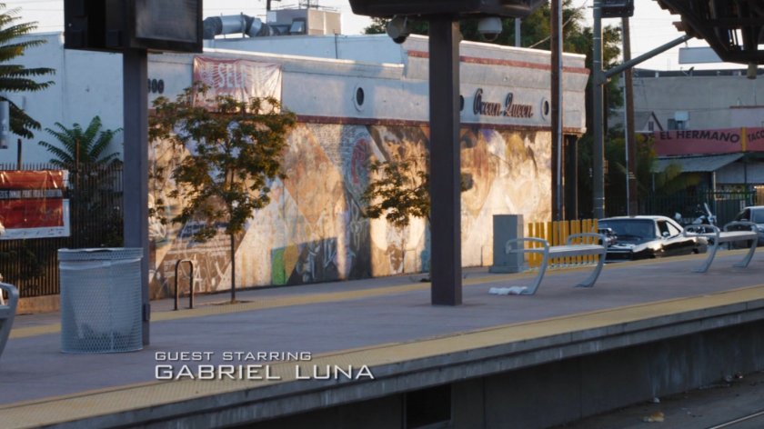 Robbie's black Charger driving past the Ghost Rider mural.