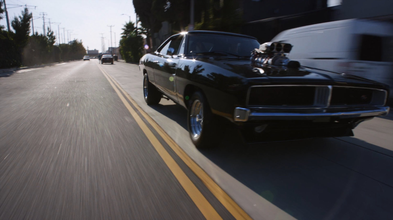 Black Charger driving on street.