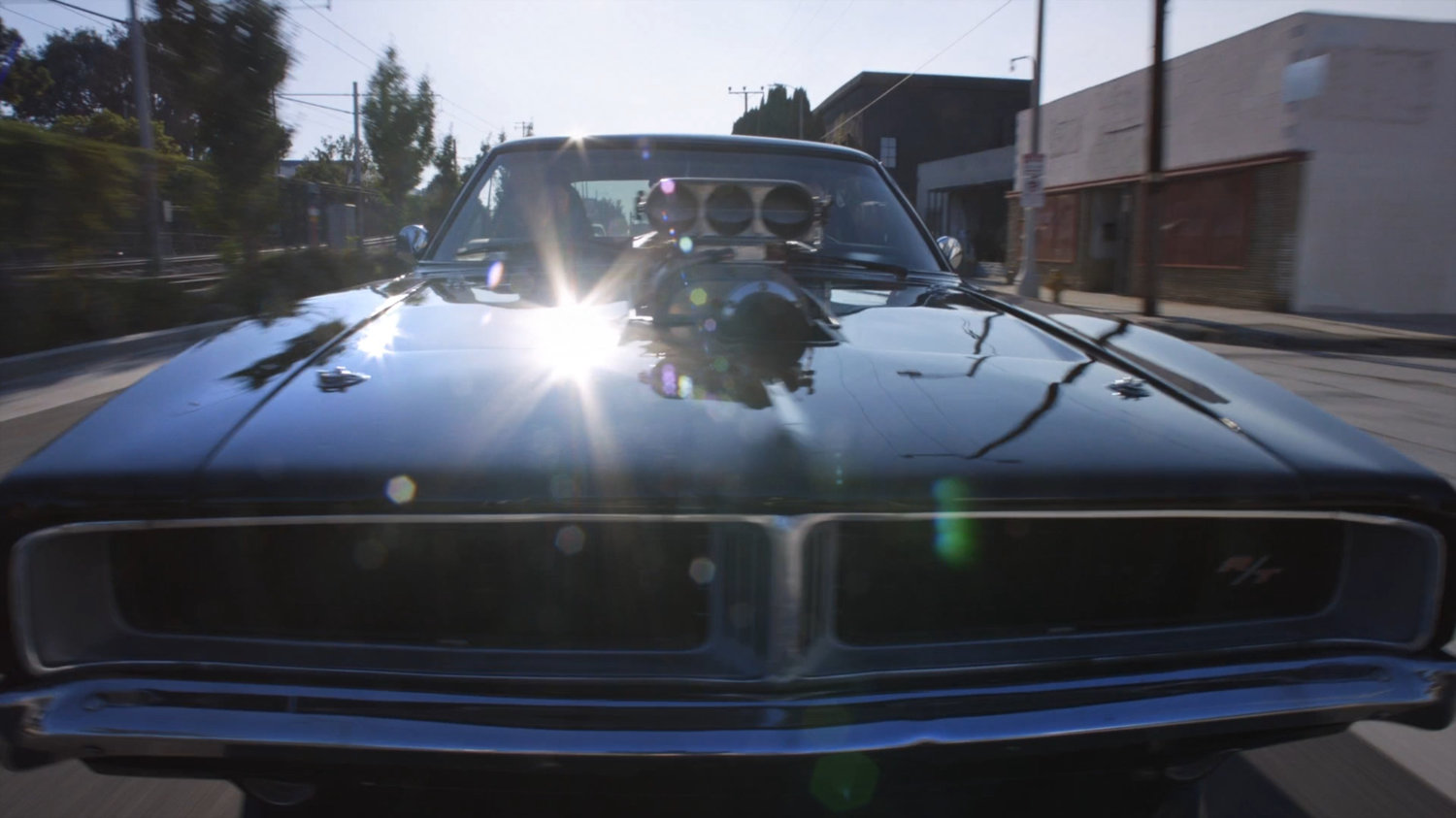 Black Charger driving on street.
