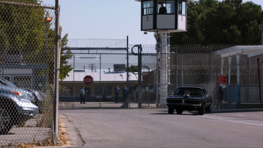 Black Charger driving away from South Ridge Penitentiary.