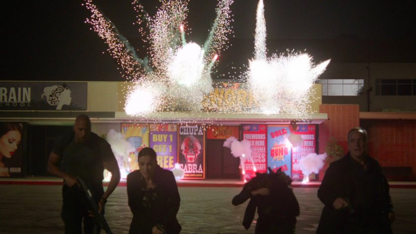 Exterior of Primed and Ready Fireworks exploding as Mack, Simmons, Daisy, and Coulson escape.