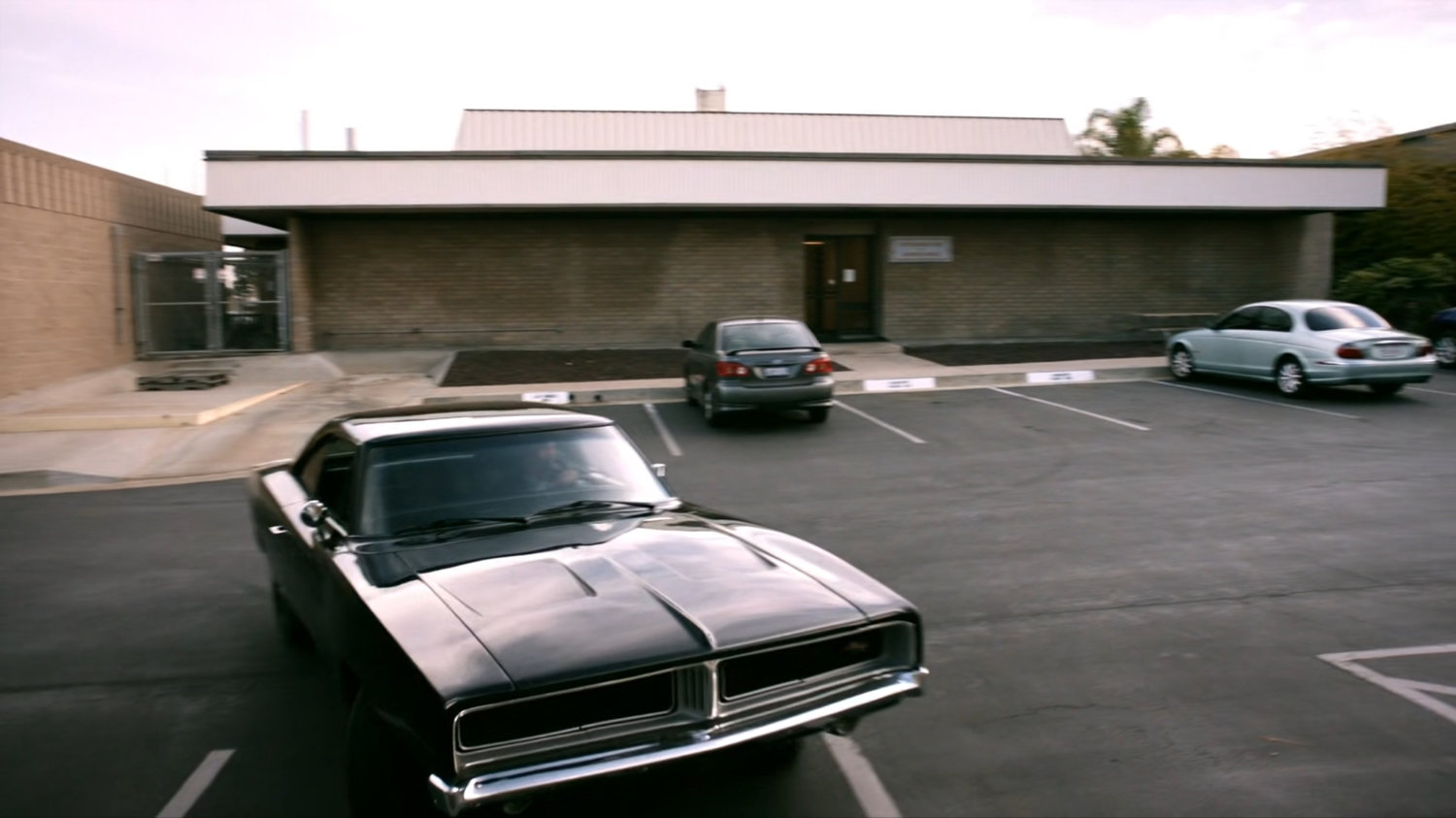 Black Charger pulling into parking lot of Momentum Labs.