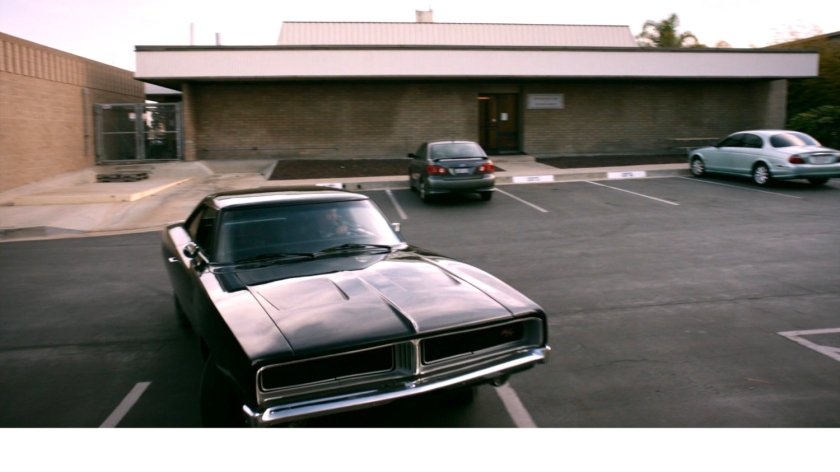 Black Charger pulling into parking lot of Momentum Labs.
