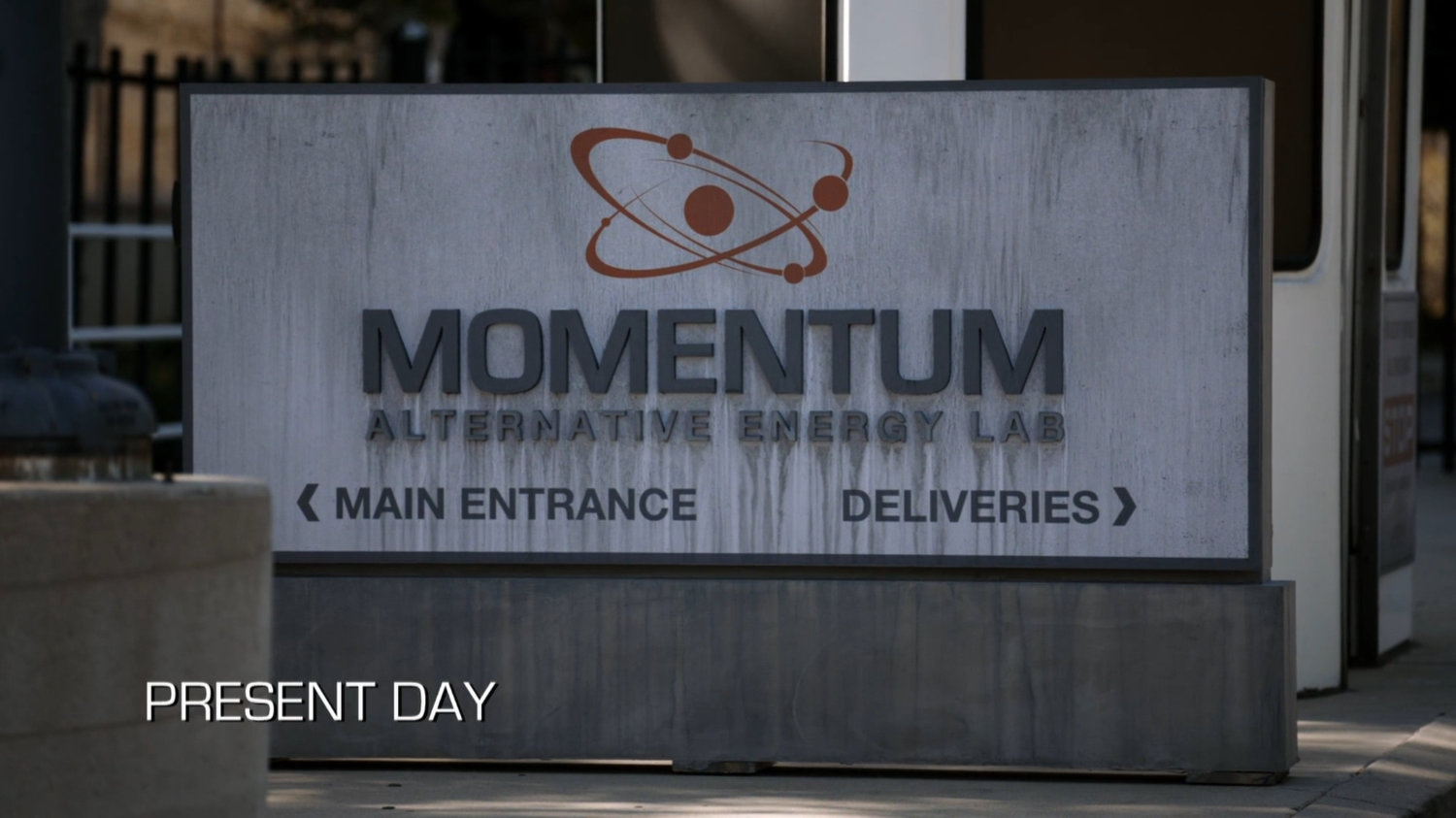 Sign outside Momentum Alternative Energy Labs. Text: Present Day.