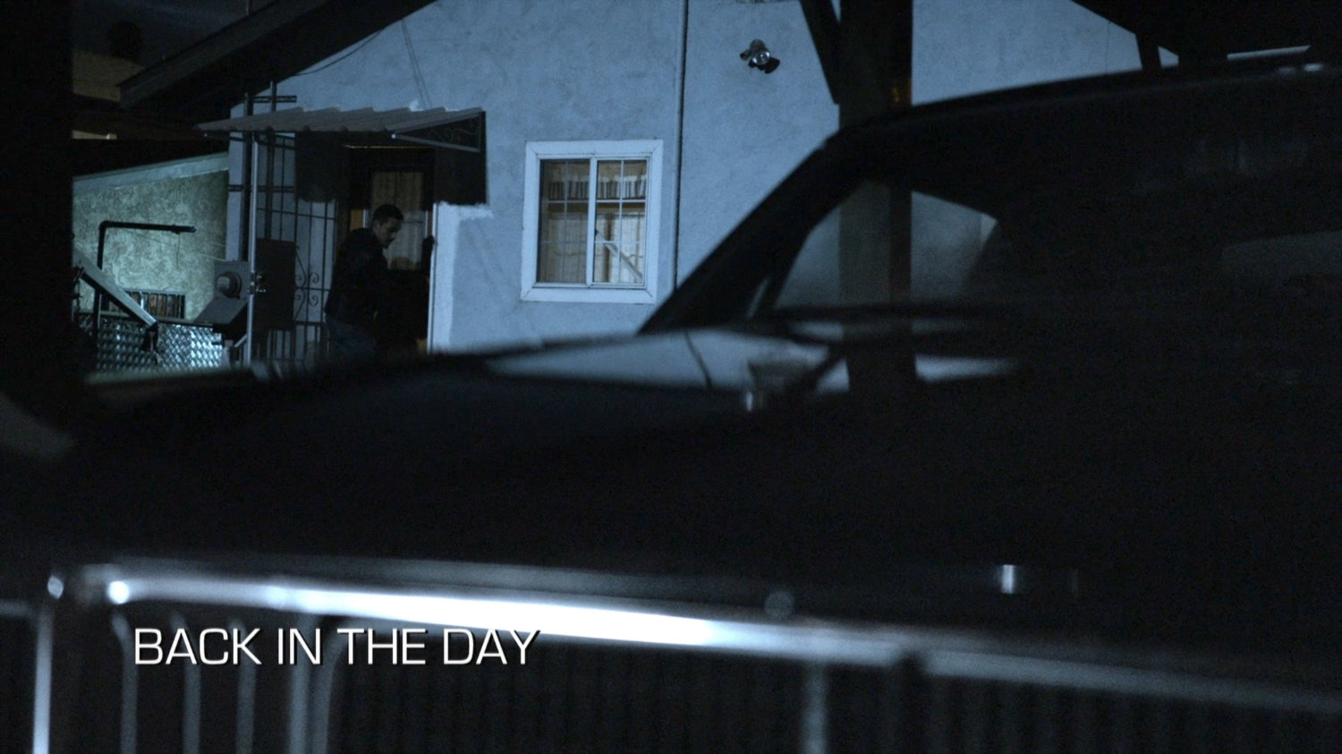 Robbie exiting the Reyes house at night. Text: Back in the Day.