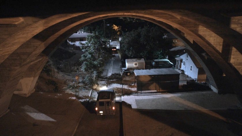 Van drive along alley under bridge and behind Reyes house.