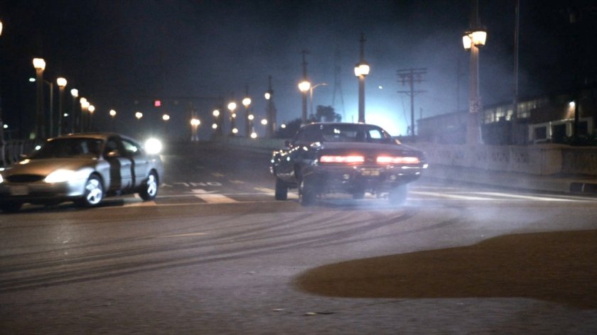 Black Charger peeling out towards bridge.