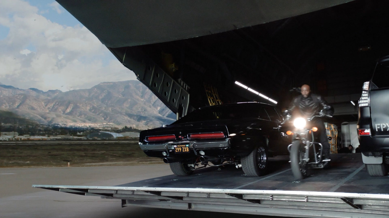 Mack riding his motorcycle off the ramp of Zephyr One at a Los Angeles airfield.