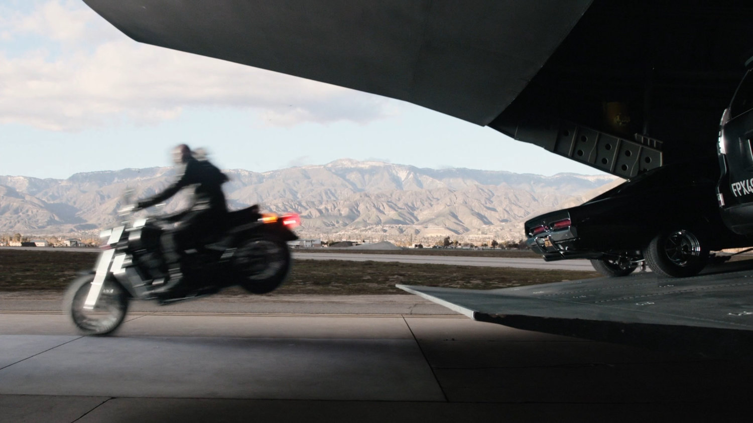 Mack riding his motorcycle off the ramp of Zephyr One at a Los Angeles airfield.
