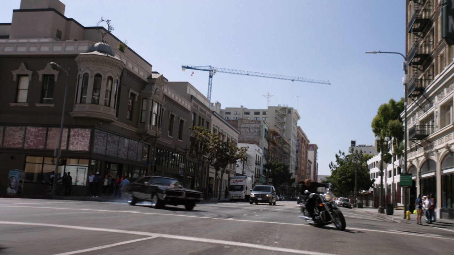 Mack on his motorcycle and black Charger taking a corner in Los Angeles.