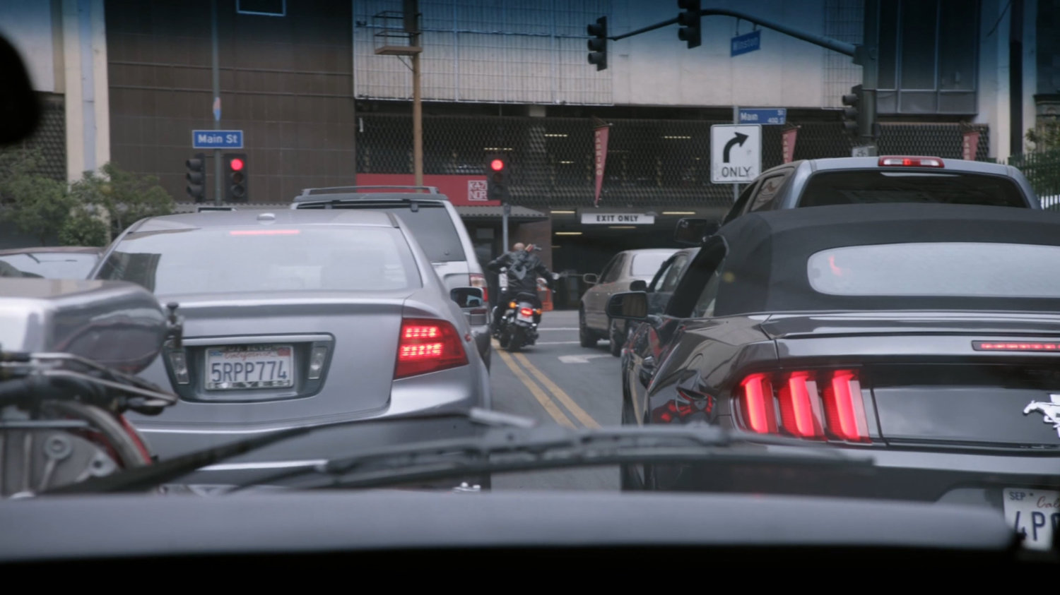 Mack on his motorcycle driving through stopped traffic in Los Angeles.