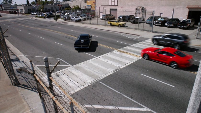 Black Charger sliding across street outside Chinatown Crew Warehouse.