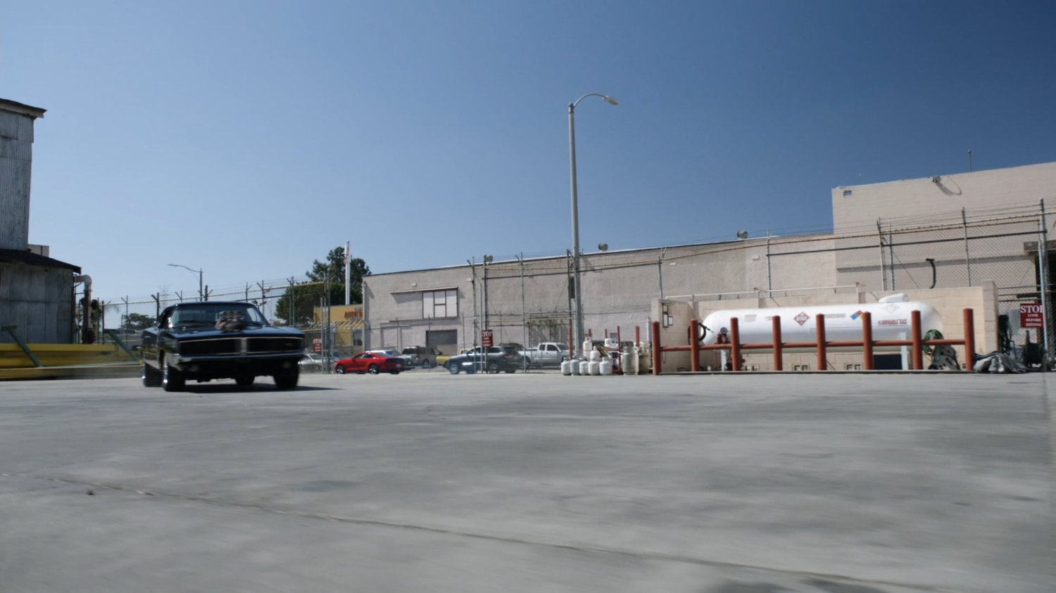 Black Charger driving through Chinatown Crew Warehouse parking lot.