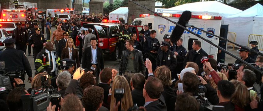Johnny, Sue, and Reed surrounded by emergency personnel and reporters under the Brooklyn Bridge.
