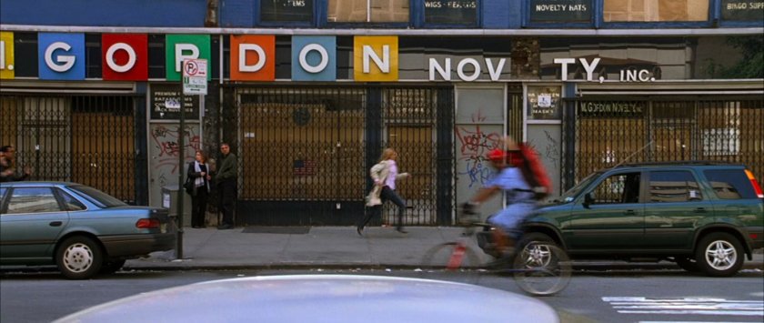 Sue running along a New York sidewalk, followed by people.