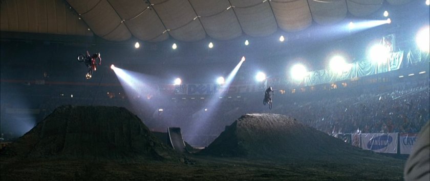 Two motorcycles leaping through the air at the XGames Arena.