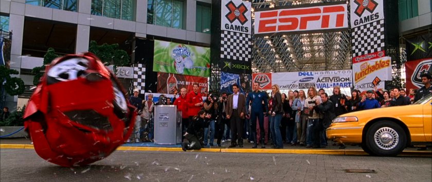 Sue, Reed, and Johnny looking at a red Ferrari ball at the entrance at the XGames Arena.