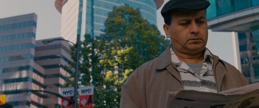 A man reading the newspaper outside the Baxter Building.