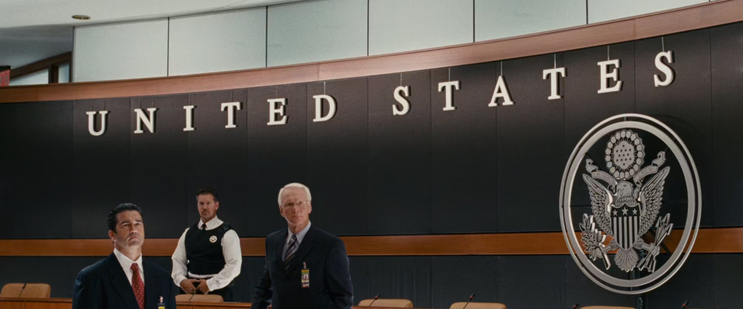 Three men standing in front of a wall that says United States.