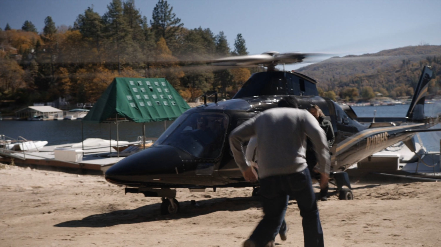 Vijay and Ellen running towards helicopter outside her lake house.