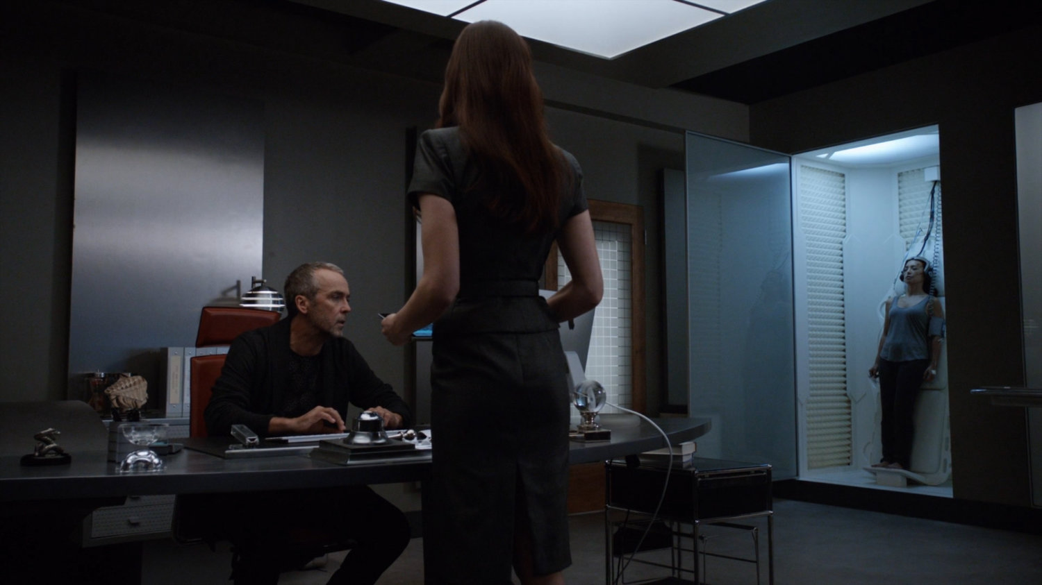 Radcliffe and Aida in his workshop with Agent May unconscious in a cubicle.
