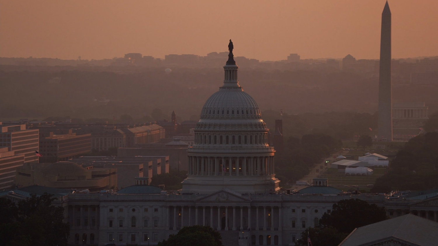 Aerial view of United States Capitol with the Washington Monument in the background.