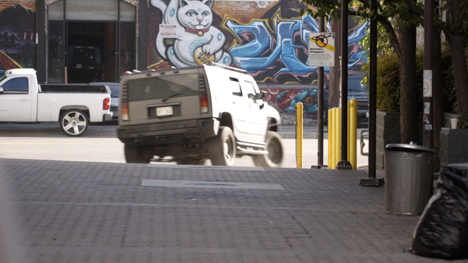 Humvee driving away from alley.