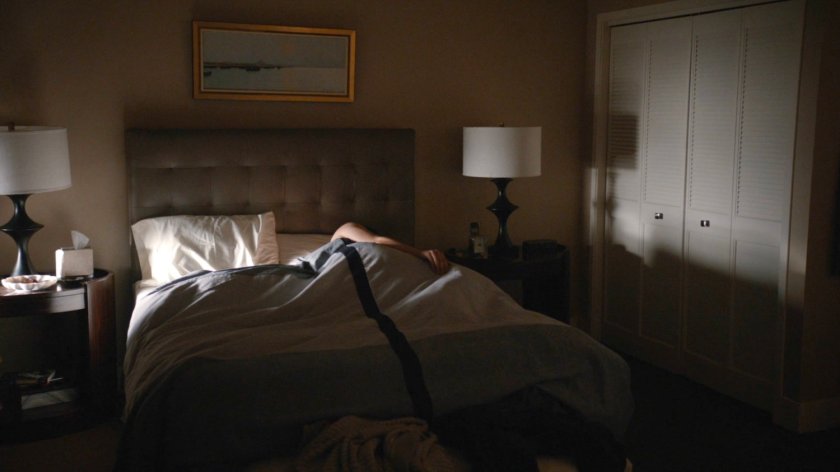 View of a man in Daisy's bed in her framework apartment.