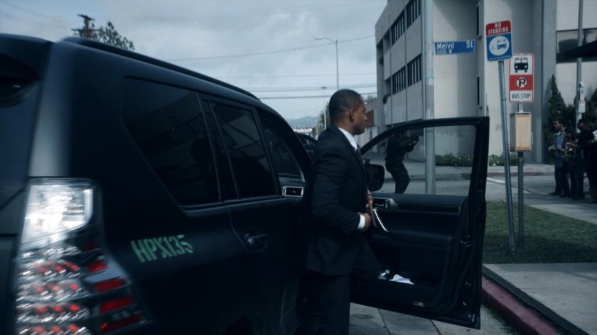 HYDRA agent gets out of SUV at a bus stop on a street corner of the Framework.
