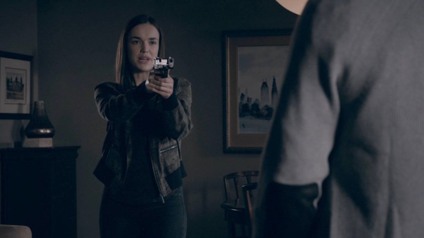 Simmons holds a gun on Alistair in his house inside the Framework.