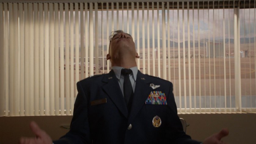 Talbot getting shot in the head inside a boardroom at a private airfield.