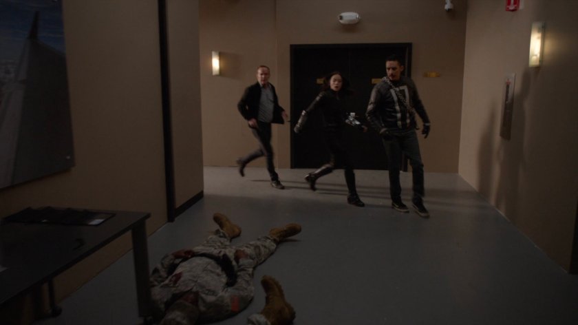 Coulson, Daisy, and Robbie in hallway at a private airfield.