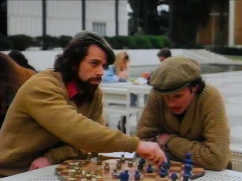 Two men playing chess in a college quad.