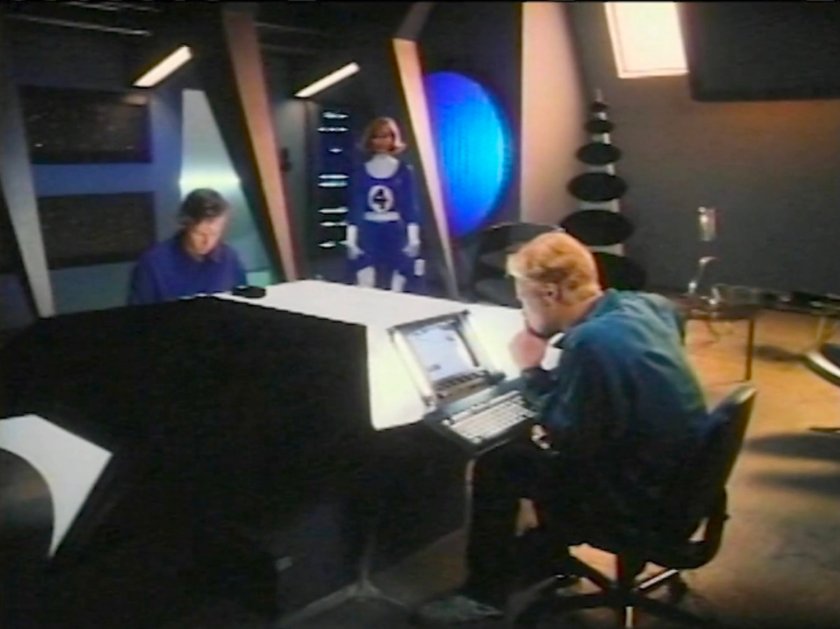 Reed and Johnny in the Baxter Building lab, with Sue entering in costume.