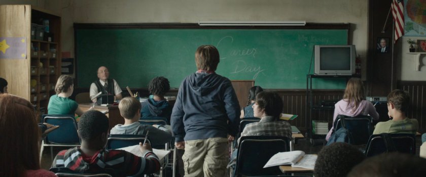 Young Reed approaching chalkboard in an elementary classroom.