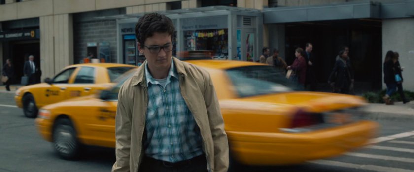 Reed crossing a street in Manhattan with taxi's passing behind him.