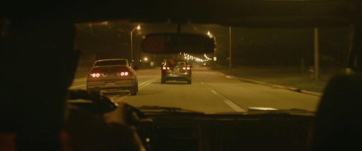 Two cars racing on a street.
