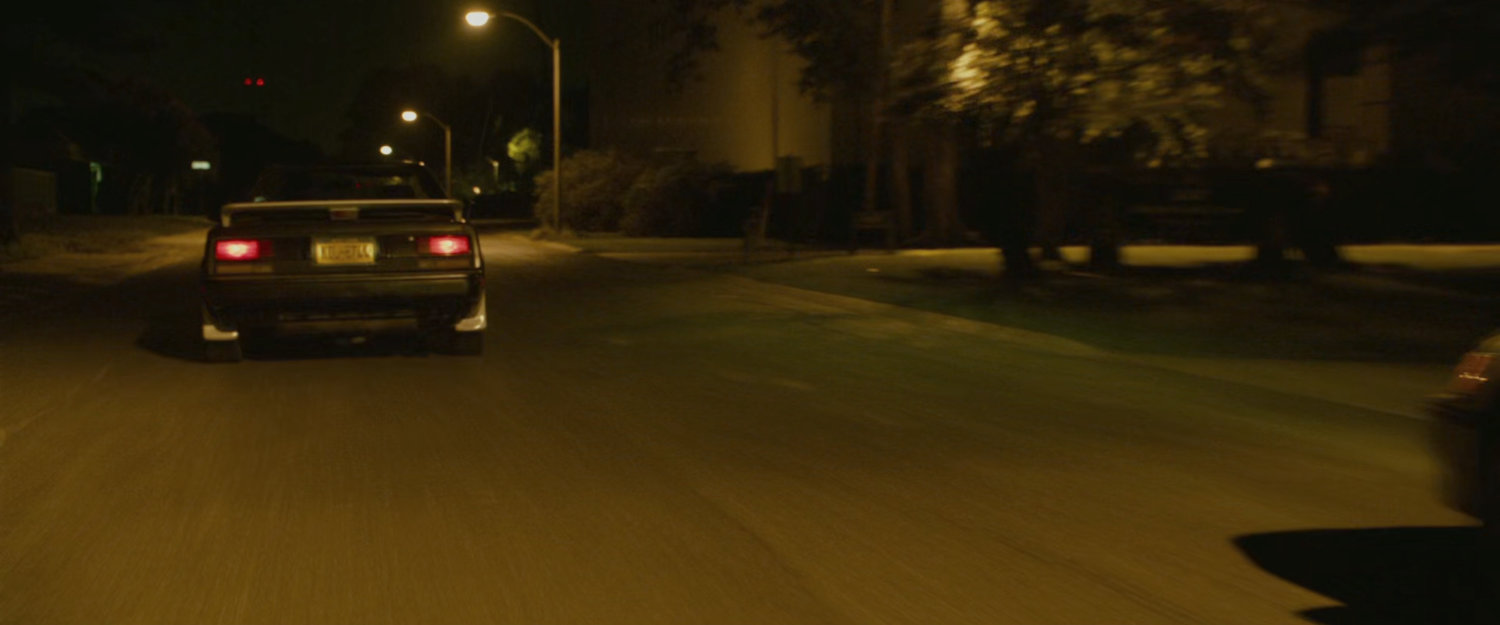 Two cars racing on a street.