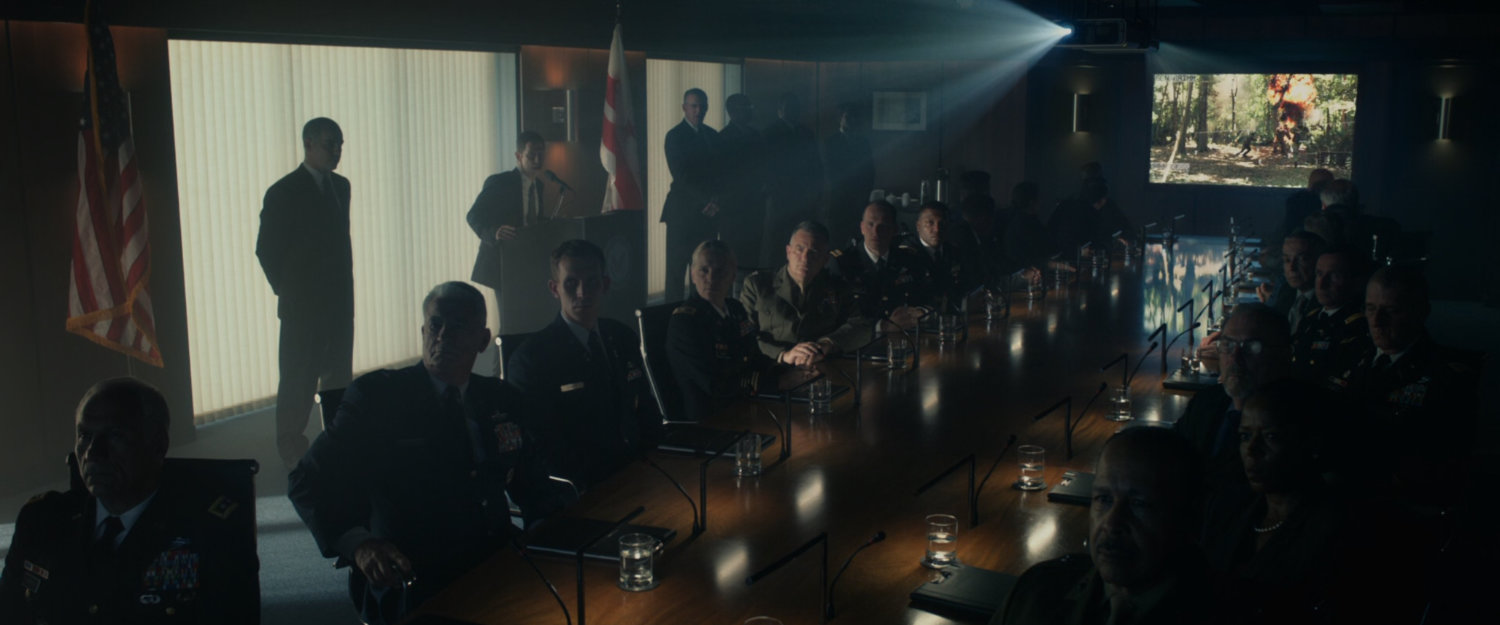 Men in a conference room at the Pentagon reviewing footage of Ben Grimm in action, codename The Thing.