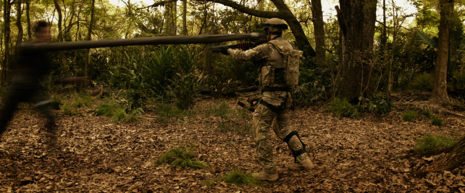 Reed stretches to punch a soldier in a South American jungle.