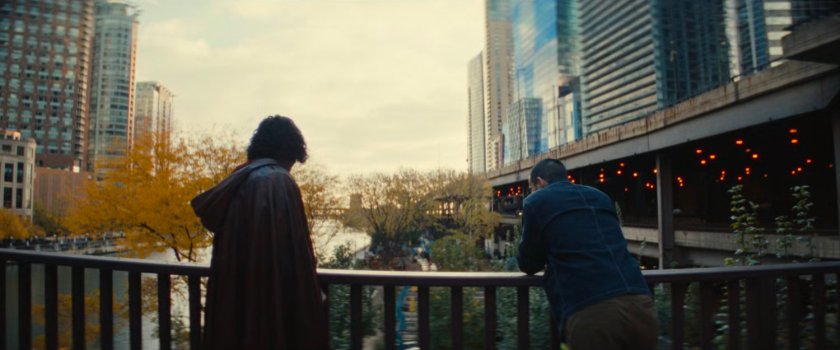 The Hood and John leaning on a railing by the river.