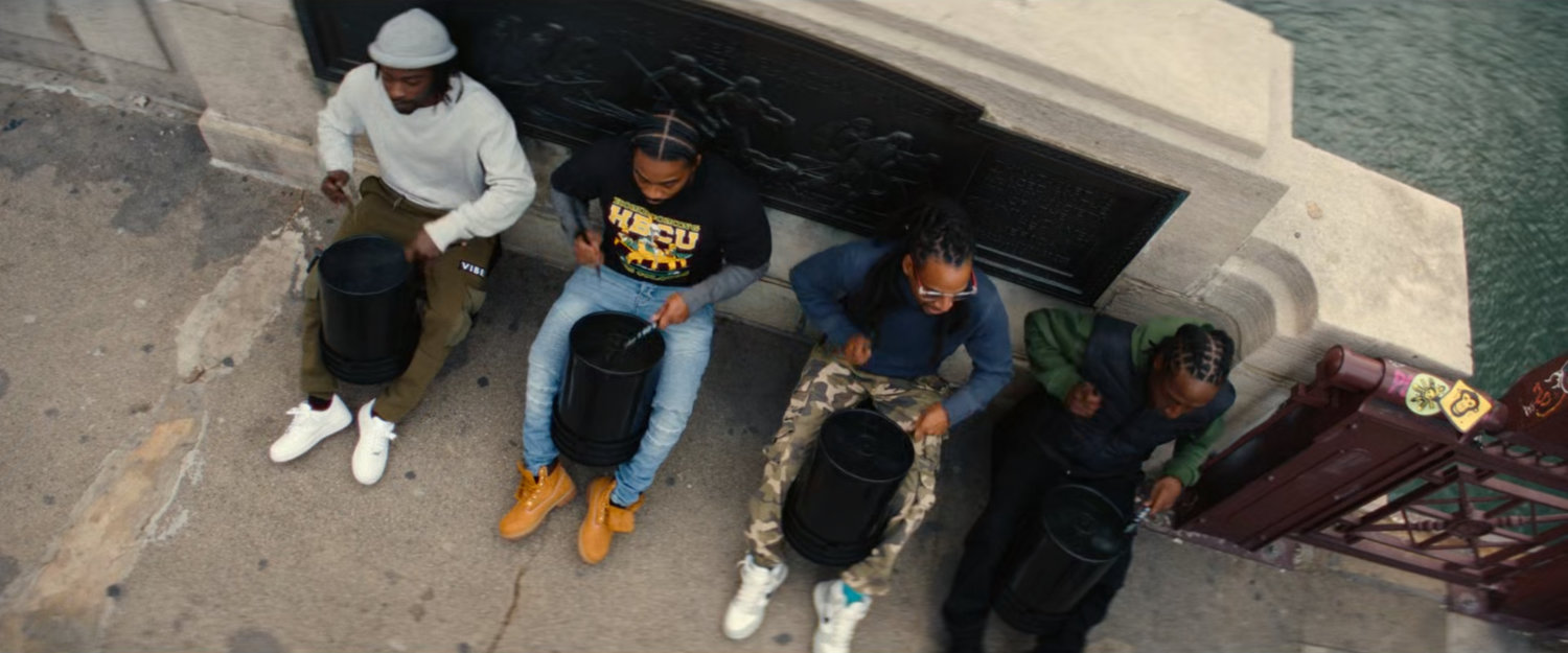 Four men drumming by a bridge in Chicago.
