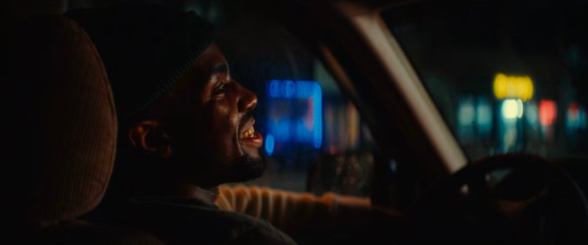 Xavier in a car outside Gary's Auto Repair.